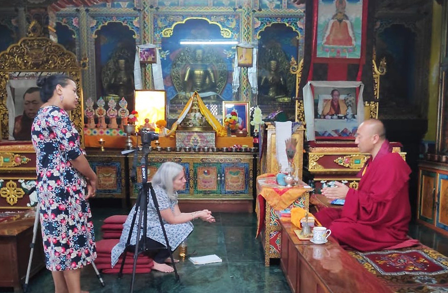 Leve and cultural heritage activist Alina Tamrakar interview the resident monk at Deva Dharma Mahavihar, a Buddhist monastery located in front of the stupa. (photo by Alok Tamrakar)