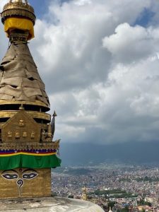The top of the stupa, looking out onto Kathmandu City. The spire, which symbolizes the steps to enlightenment, is covered in fabric for each year during the summer season. (photo by Lauren Leve)